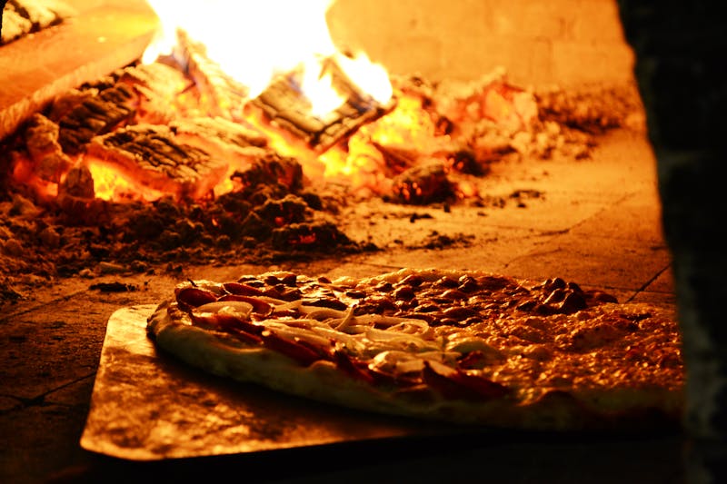 Fresh Giordanos deep dish pizza coming out of the oven